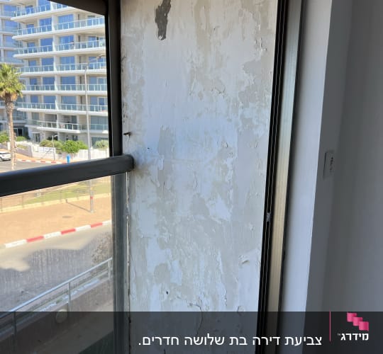 קיר עם קילופי צבע ליד חלון